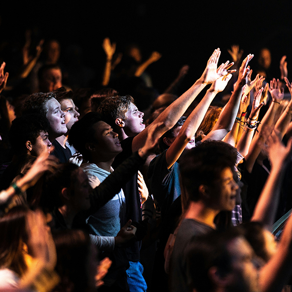 people worshiping with hands raised