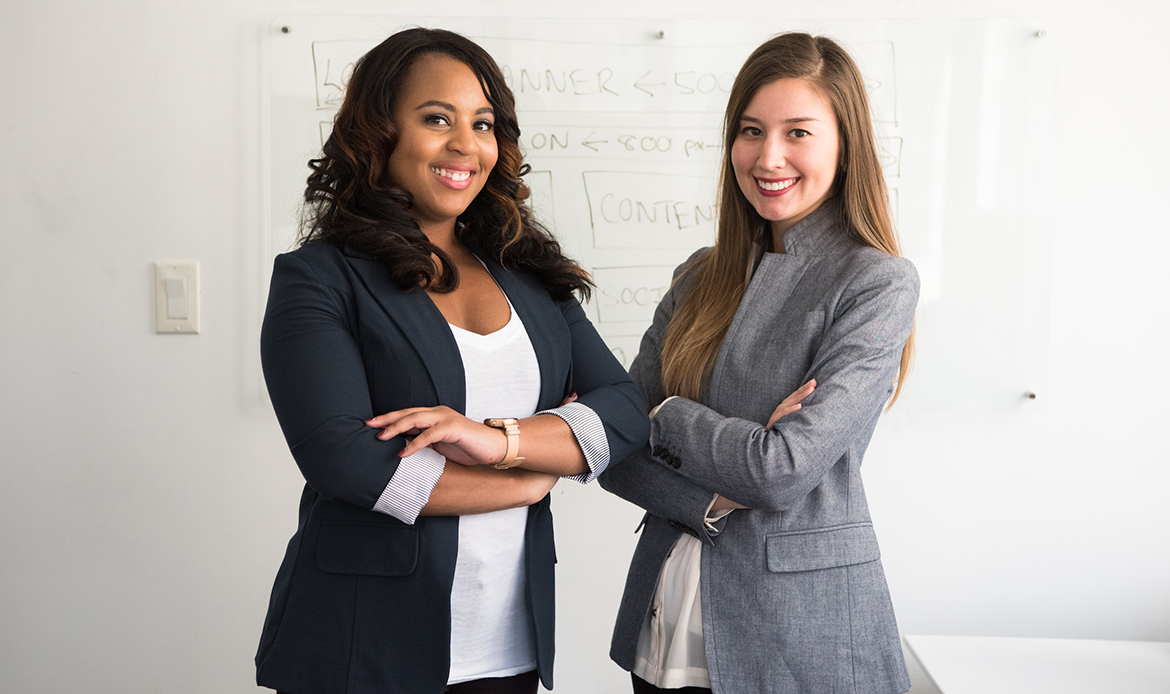 two women standing with arms crossed