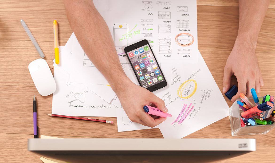 person working at a desk with highlighters and a plan